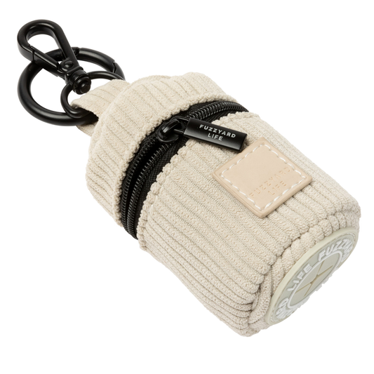 Sandstone corduroy poop bag dispenser keychain pouch with a black zipper on a white background